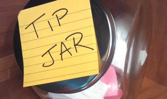 Glass Jar with a note that says "Tip Jar"